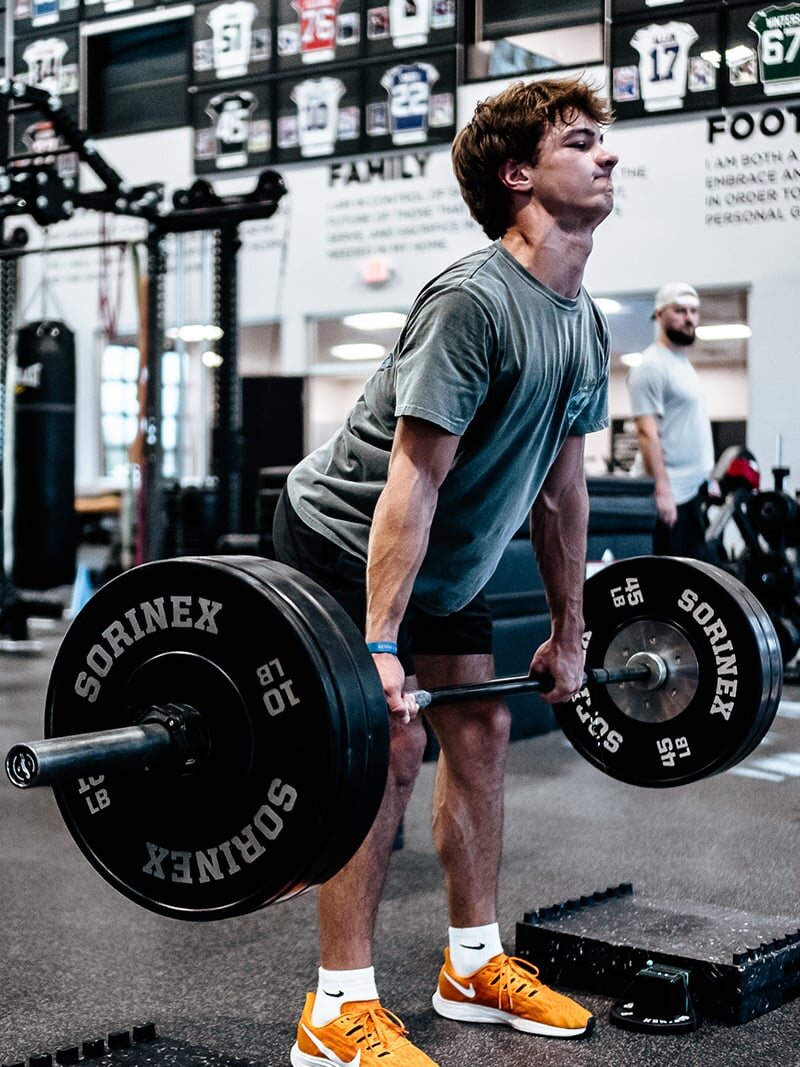 An athlete setting up for a barbell lift during a Youth Training session